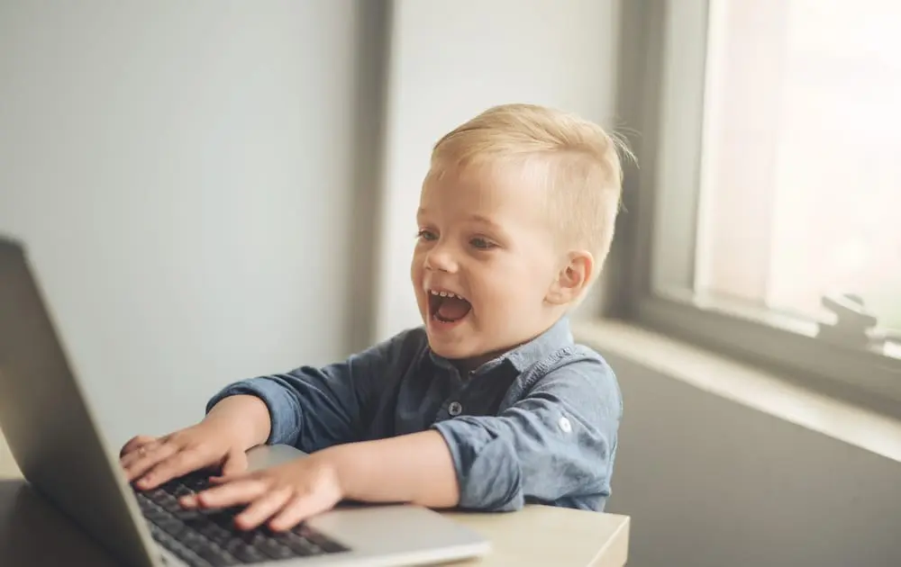 Child playing on laptop children exploring Montessori sensorial materials to enhance tactile learning