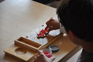 students collaborating on a project using Montessori math materials